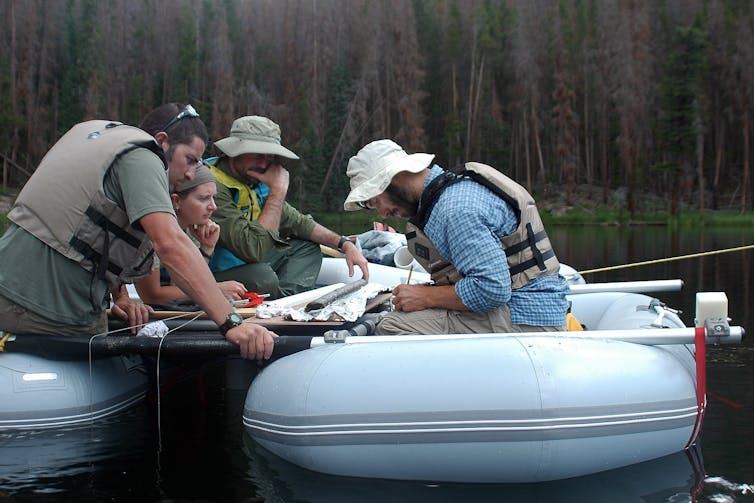 Scientists on a raft examining a sediment core