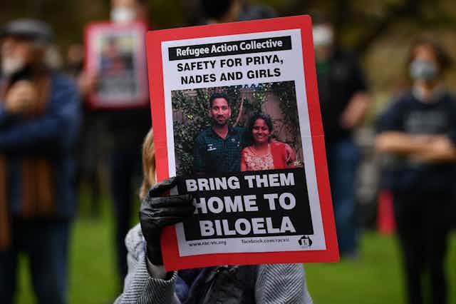 A protestor, holding an image of the Bioela Tamil family