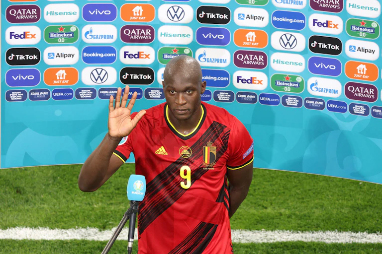 Striker Romelu Lukaku of Belgium speaking to the press in front of an advertisement screen