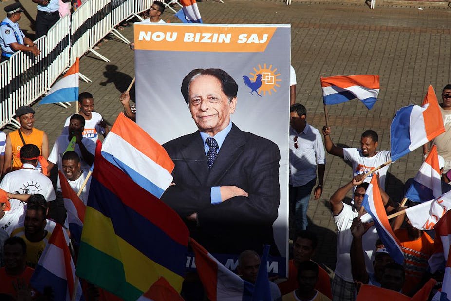Supporters of Anerood Jugnauth carry a poster with his image 