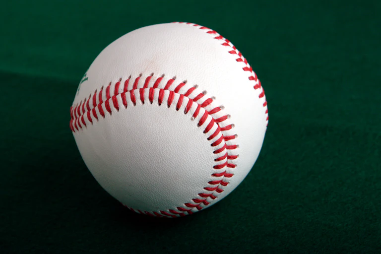 A baseball against a green background