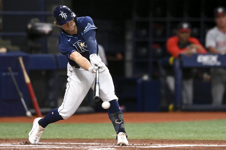 A baseball player swinging and missing a pitch.