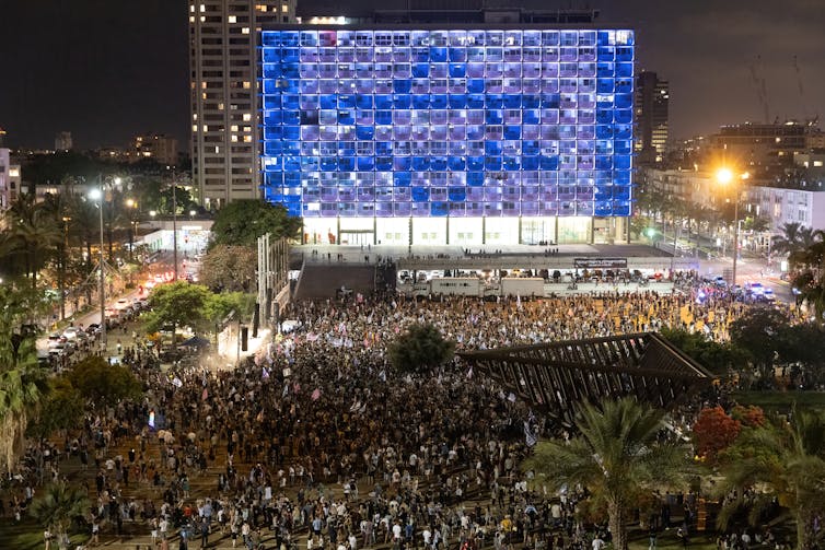 Thousands of people dancing in a public square in Tel Aviv, Israel.