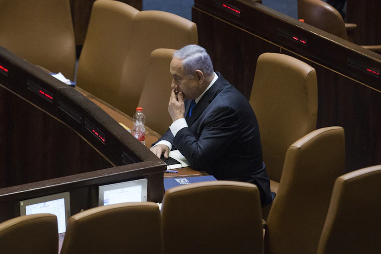 Benjamin Netanyahu sitting alone in the Israeli Parliament as he awaits the vote that could oust him from his longtime job.