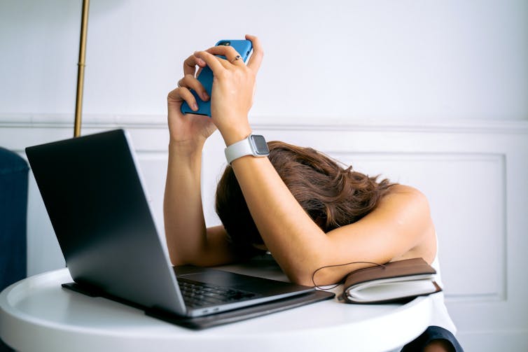 A woman slumps on her laptop