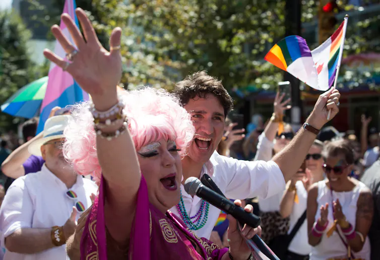 Justin Trudeau stands behind a drag queen during a Pride parade