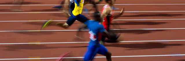 blurred sprinters on running track