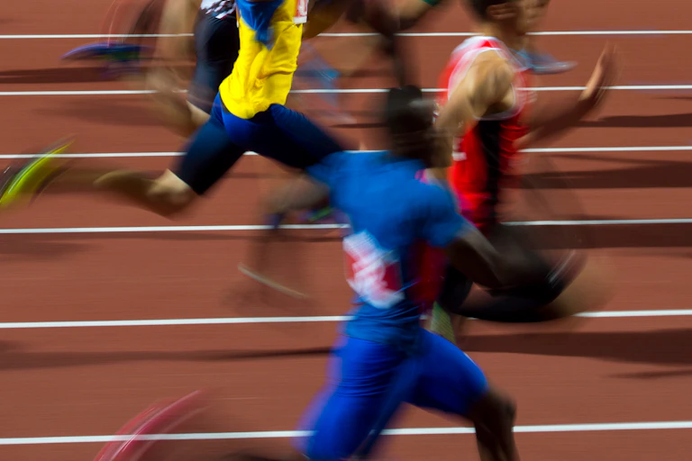 blurred sprinters on running track