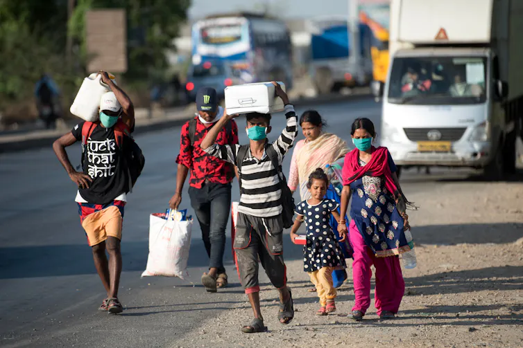 Migrant workers walk on the highway on their journey back home during a nationwide lockdown to fight the spread of Covid-19.