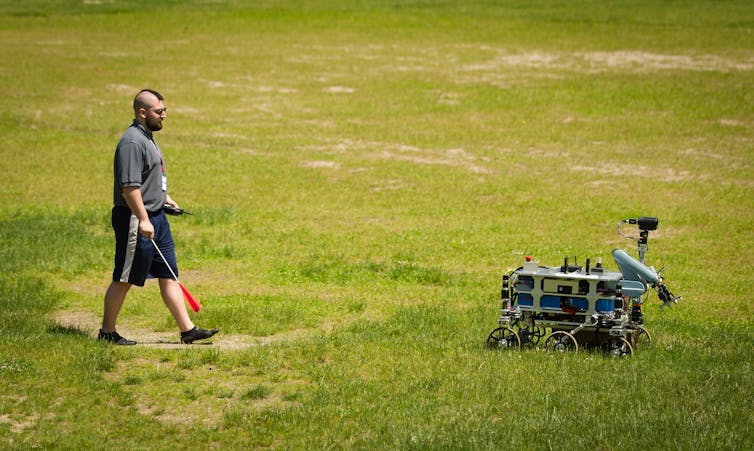 A person walks behind an autonomous robot