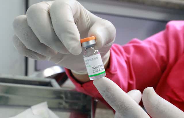 A nurse holding a vial of Sinopharm vaccine