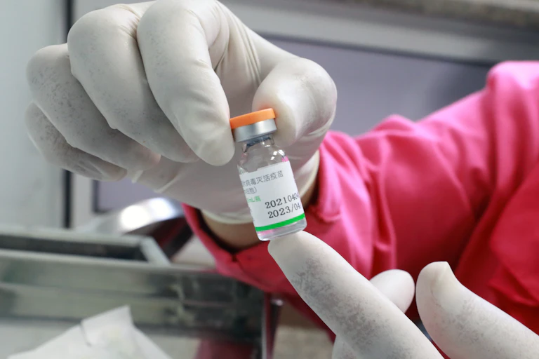 A nurse holding a vial of Sinopharm vaccine
