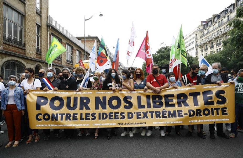 Jean-Luc Mélenchon derrière une banderole contre les idées d'extrême-droite, à la "Marche des libertés" le samedi 12 juin.