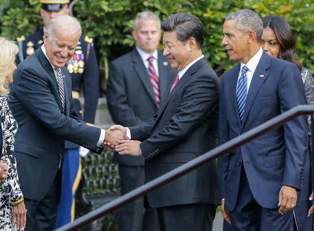 Joe Biden shakes hands with Xi Jinping while Barack Obama looks on