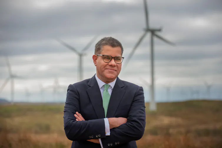 Man stands in front of wind turbines
