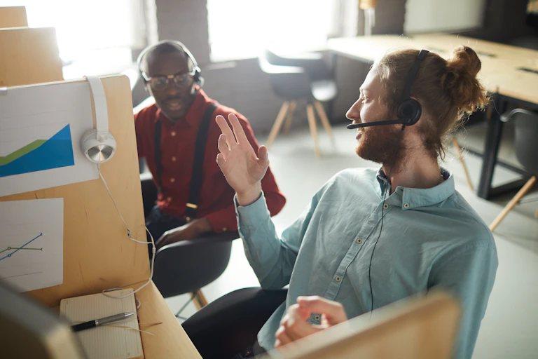 Deux employés côte à côte discutent au travail