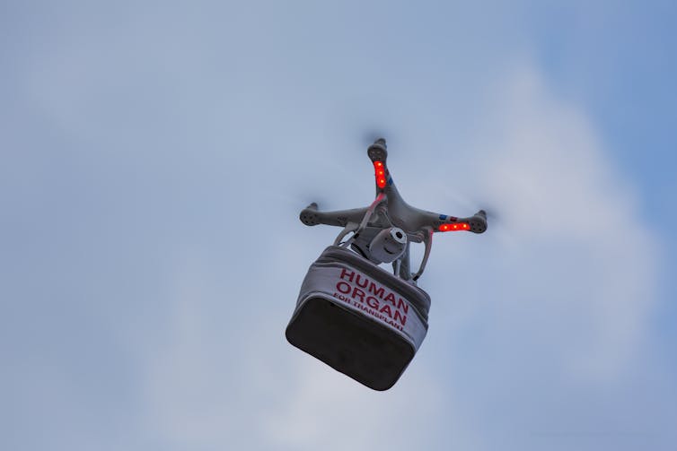 a drone flies carrying a package labelled HUMAN ORGAN