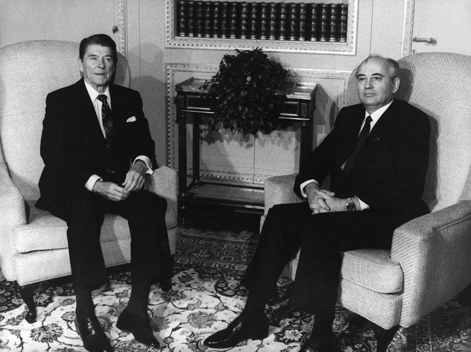 A black and white photo of Ronald Reagan and Mikhail Gorbachev seated in armchairs.