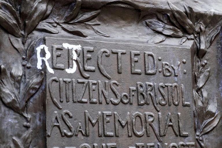 The statue of Edward Colston in Bristol with the writing changed from 'erected by the citizens of Bristol as a memorial' to 'rejected by the citizens of Bristol as a memorial'.