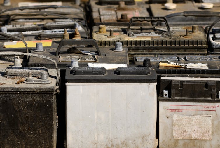 A pallet filled with rusted car batteries.