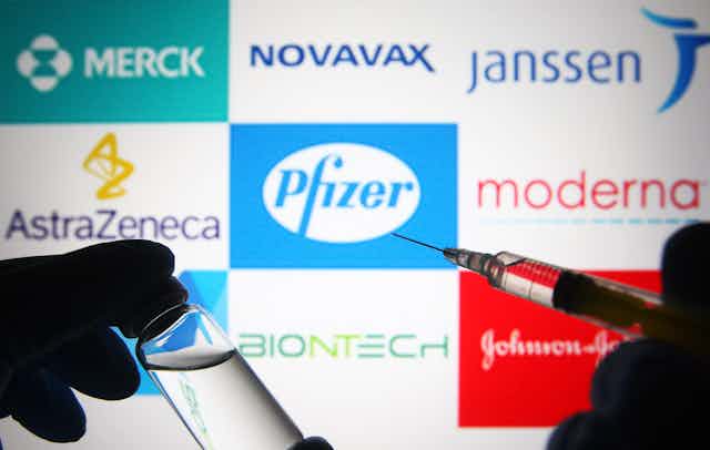 logos of vaccine-makers behind a syringe