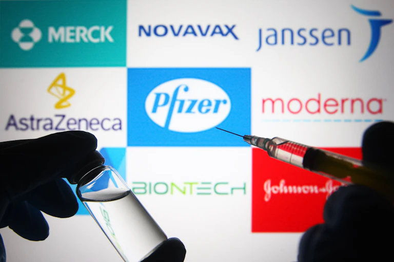 logos of vaccine-makers behind a syringe
