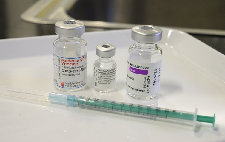 frascos de três vacinas com seringa