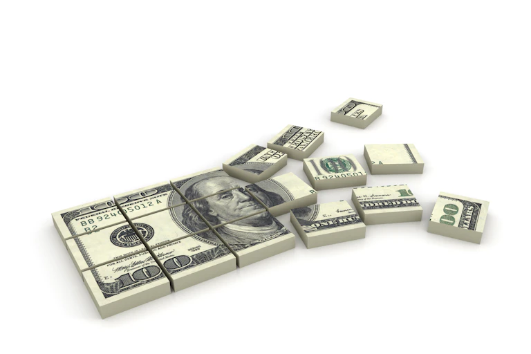 Stack of $100 bills broken into pieces