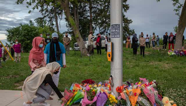 Mourners leave flowers at the site where the Afzaal family was hit by a driver.