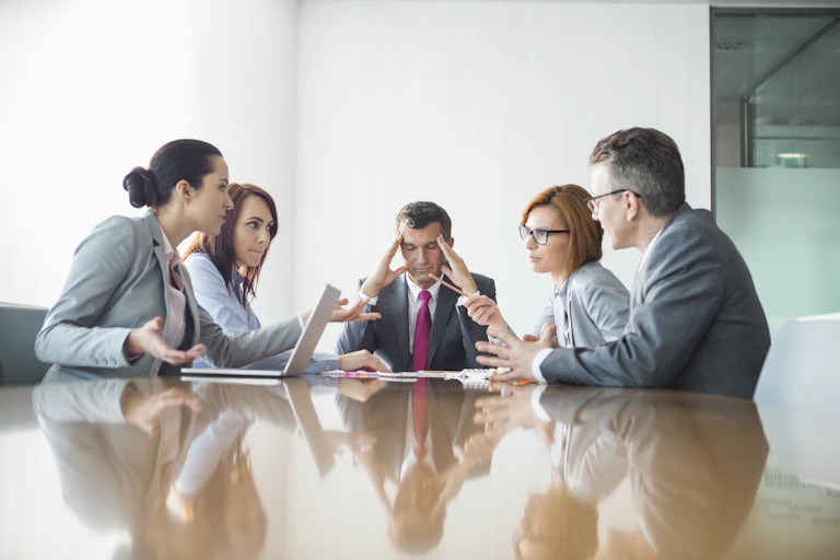 Man has head in hands as he chairs an acrimonious meeting