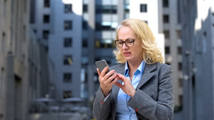 Women grimaces at message on phone