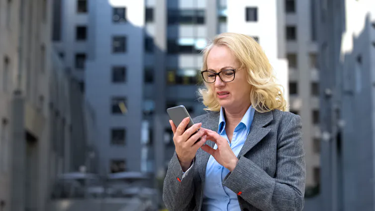 Women grimaces at message on phone