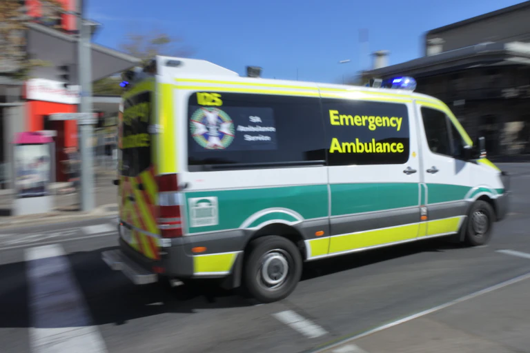 Ambulance rushing off to emergency along city street