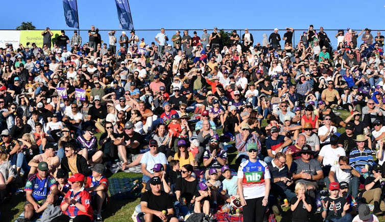 Football crowd sitting on a hill.