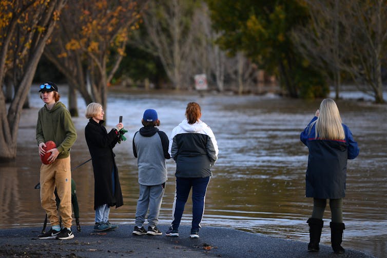 Five people looking at a flooded road