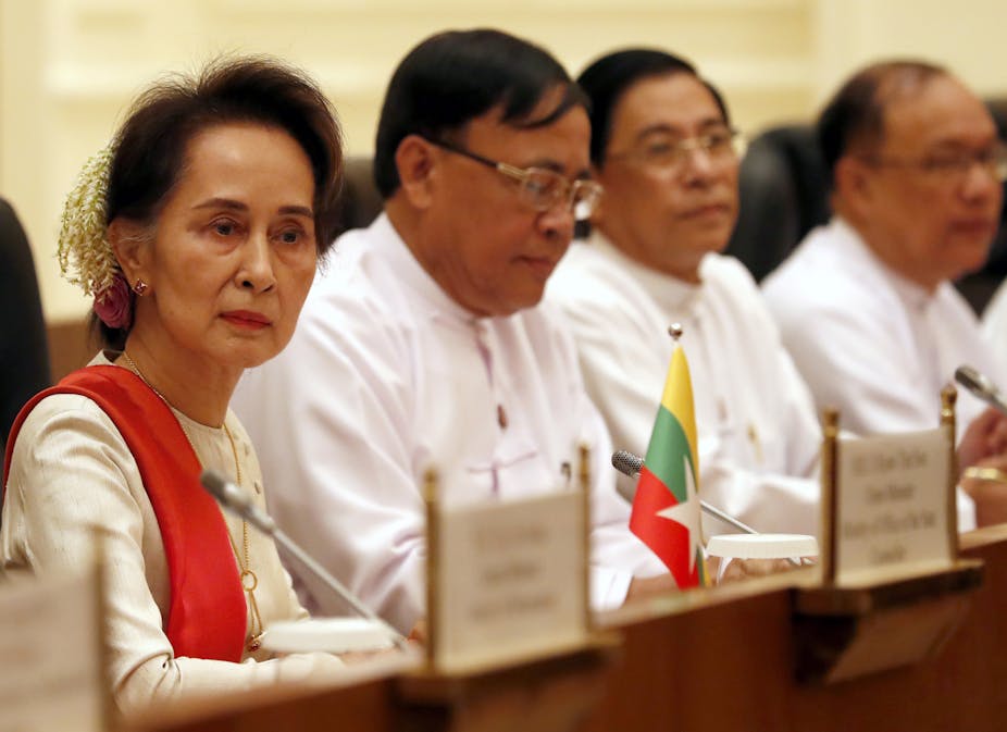 Myanmar leader Aung San Suu Kyi sitting at a conference with several colleagues form the National League for Democracy.