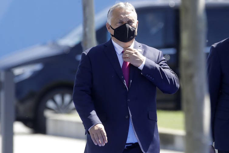 Viktor Orban, wearing a face mask, arrives at a recent NATO conference