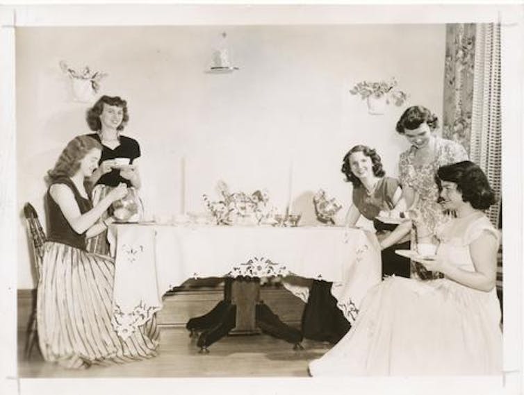 Women sit around a table having afternoon tea.