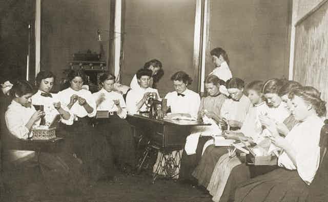 An archive photo of women sitting in a circle doing embroidery.