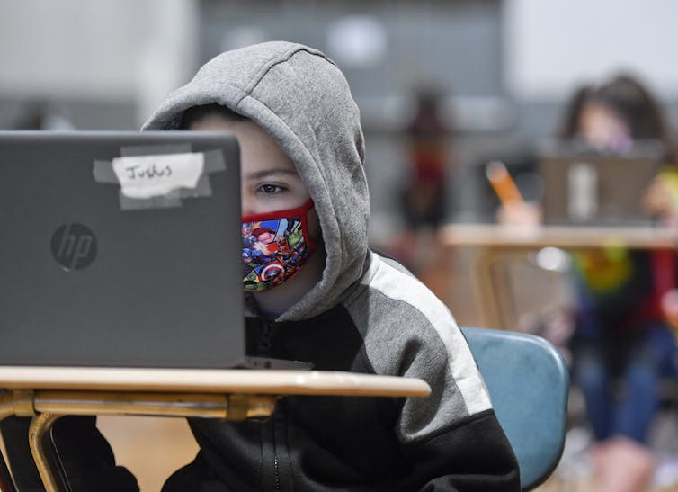 6-year-old boy does his school work on a laptop computer