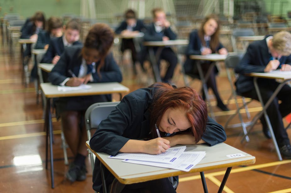 Students in uniform sit their GCSEs in a school hall
