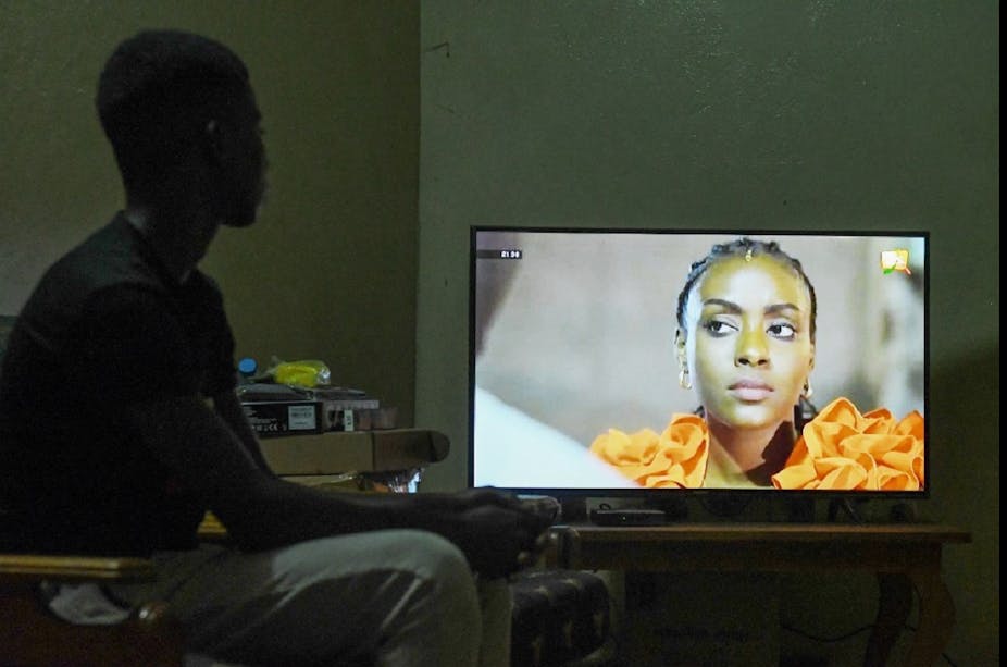 Un enfant regarde une série sénégalaise à la télévision