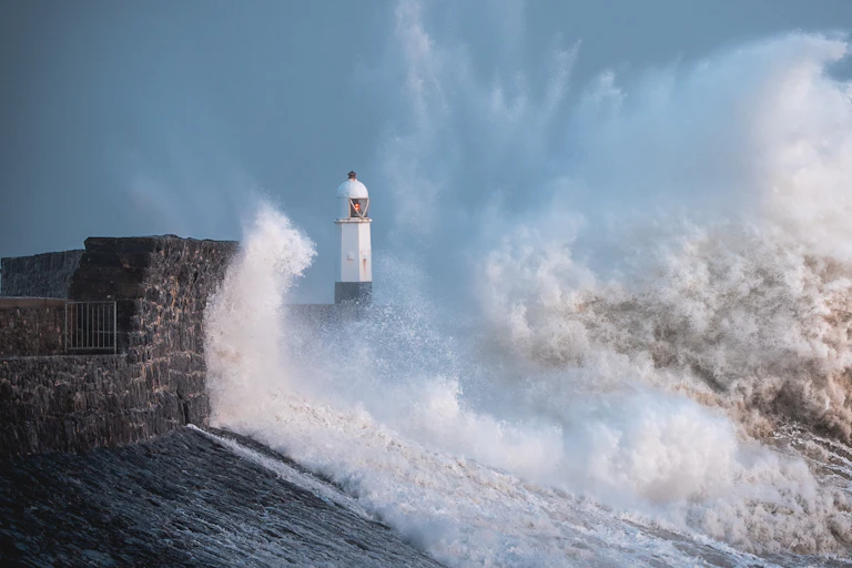 A lighthouse is buffeted by large waves during a storm.