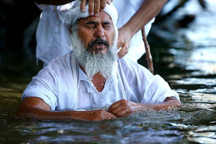 A follower being baptised during a Mandaean baptism ceremony in the Nepean river at Emu Plains on October 26, 2014 in Sydney, Australia.