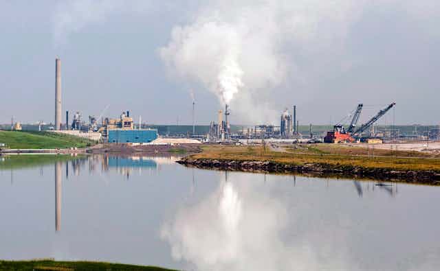 An oilsands facility is reflected in a tailings pond