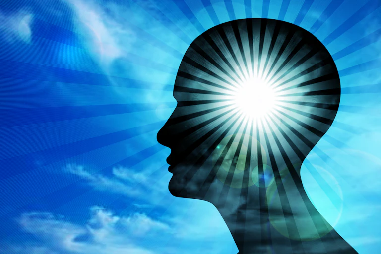 An illustration of a person's head in silhouette against a blue sky that is illuminated with a ray of light emanating outwards.