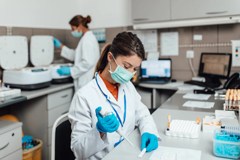 Lab technicians work while wearing masks.