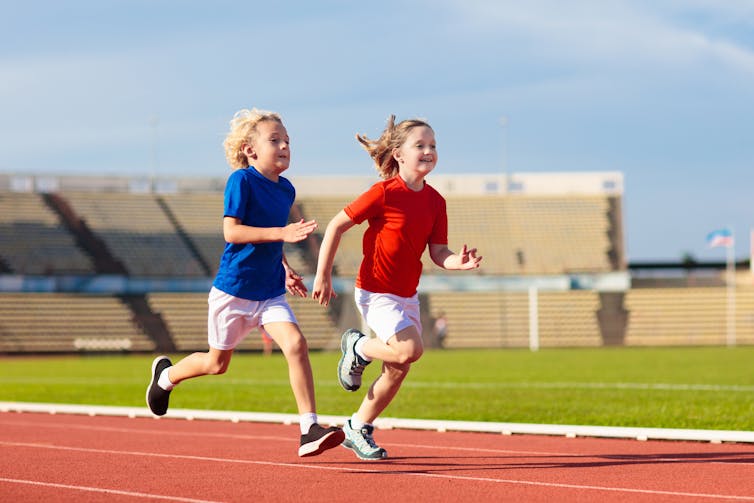 Two kids running on a track