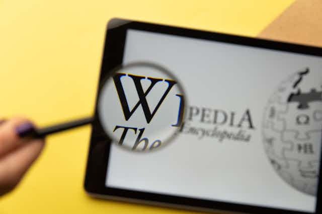 Lupa sobre página de Wikipedia en una tableta.