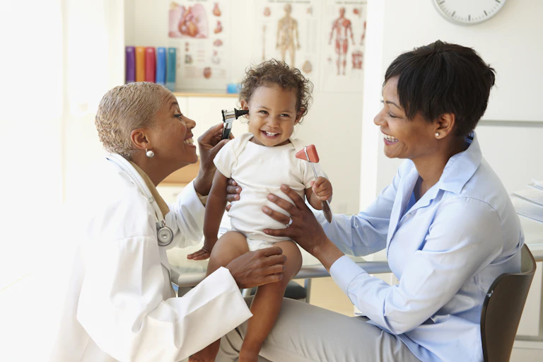 A doctor screening toddler's hearing.